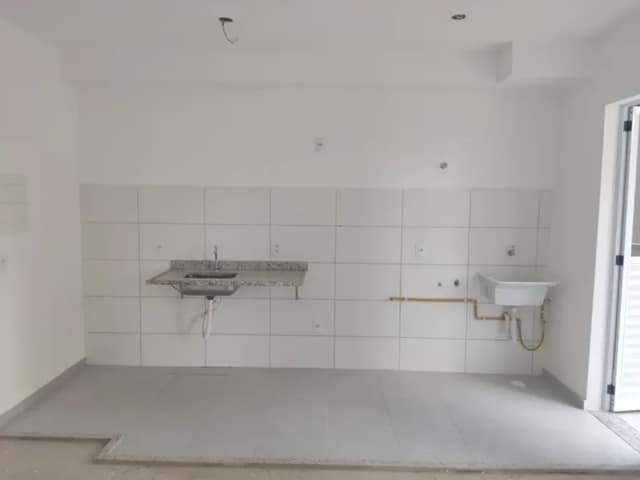 Área de serviço com bancada de granito e piso em porcelanato
