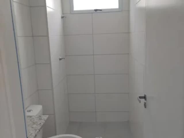 Banheiro com revestimento branco e janela