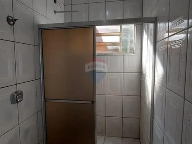 Banheiro com paredes em azulejos e box