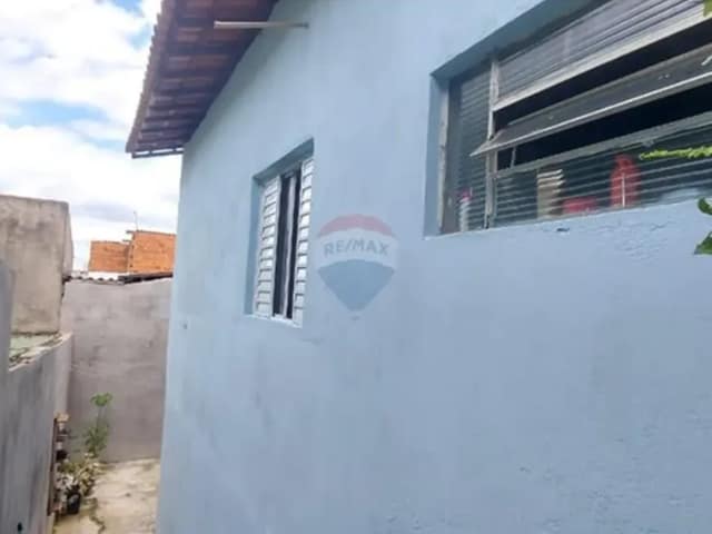 Fachada da casa com pintura azul e janelas com venezianas