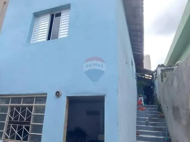 Fachada de casa com pintura azul e escada lateral