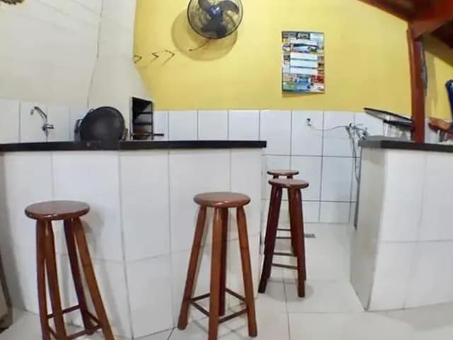 Área Gourmet com bancada e revestimento de azulejo branco