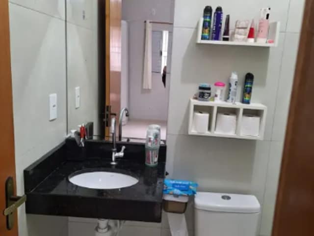 Banheiro com bancada de granito e espelho