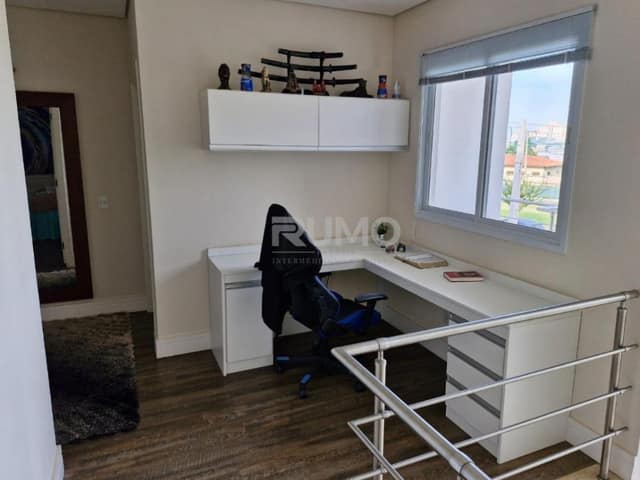 Escritório com mesa em L, armários e piso laminado