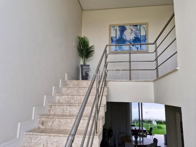 Sala com escada em granito e guarda-corpo de metal