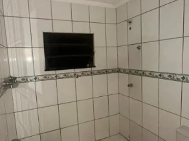 Banheiro com revestimento de azulejos brancos e friso decorativo
