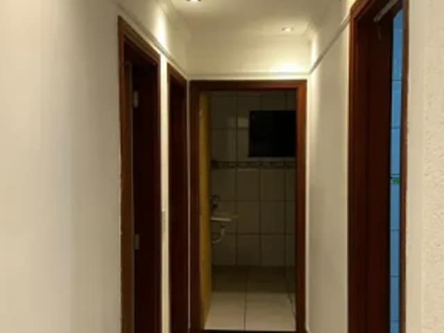 Corredor com piso em porcelanato e iluminação embutida