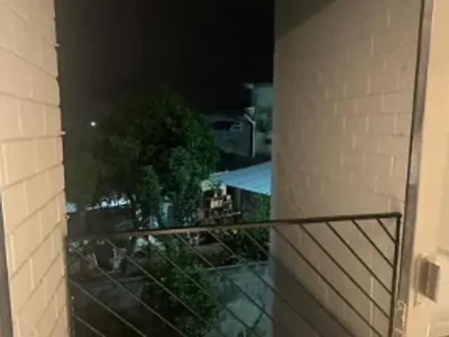 Sacada com piso cerâmico e guarda-corpo de vidro