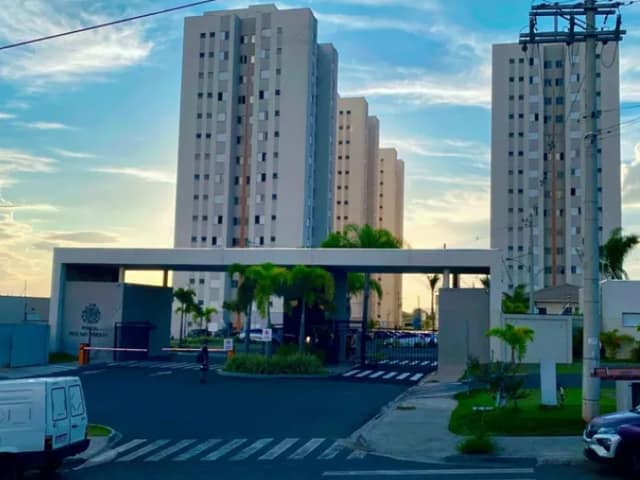 Fachada de condomínio com portaria e entrada de veículos