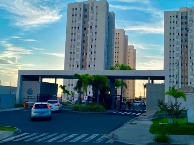 Fachada do condomínio com portaria e paisagismo