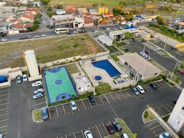 Área comum com piscina, quadra de basquete e estacionamento